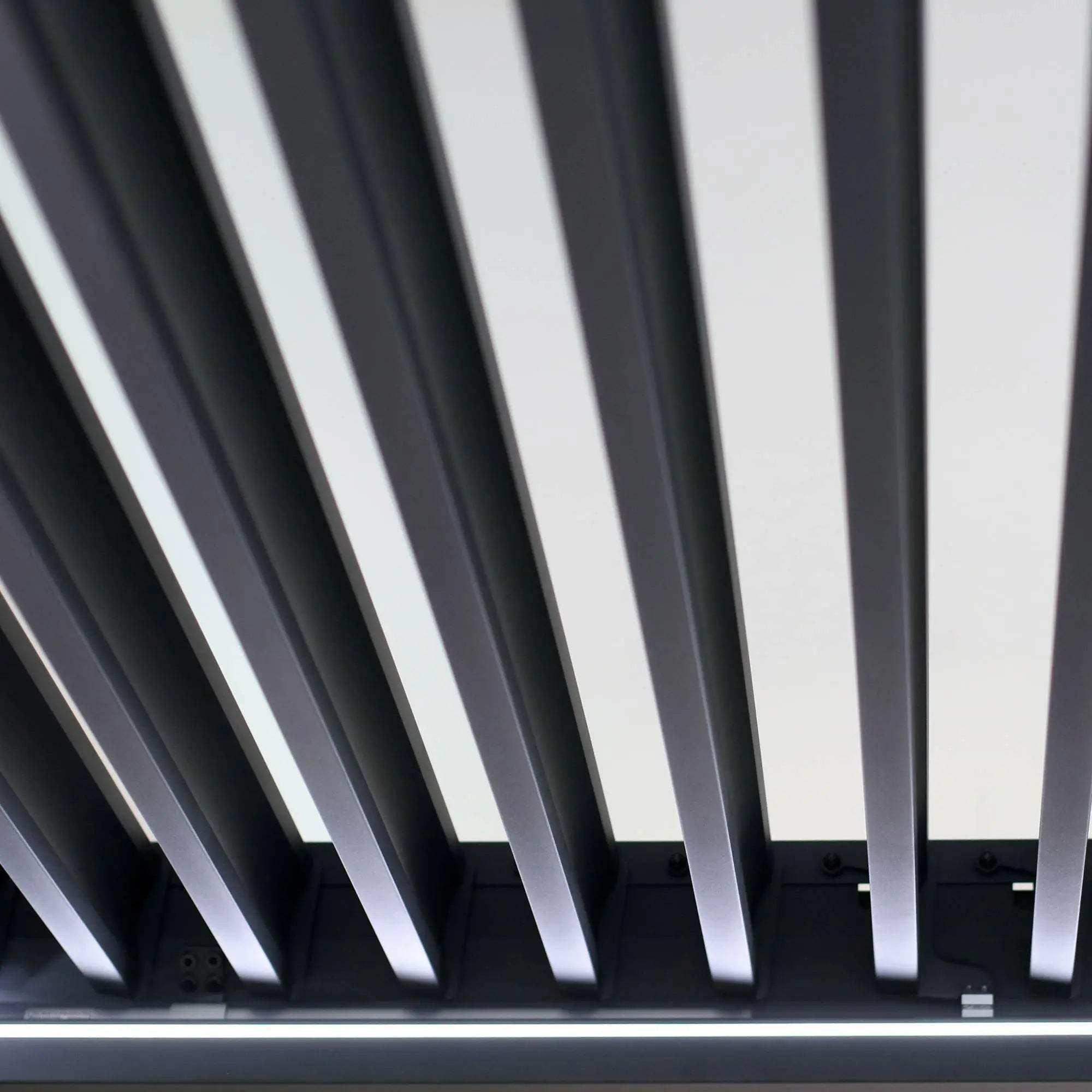 Die Pergola MotionFlex 300 von Wellis verfügt über einen Aluminiumrahmen in Mattanthrazit, elektrische Lamellen, eine integrierte LED-Beleuchtung und eine optionale Seitenbeschattung.