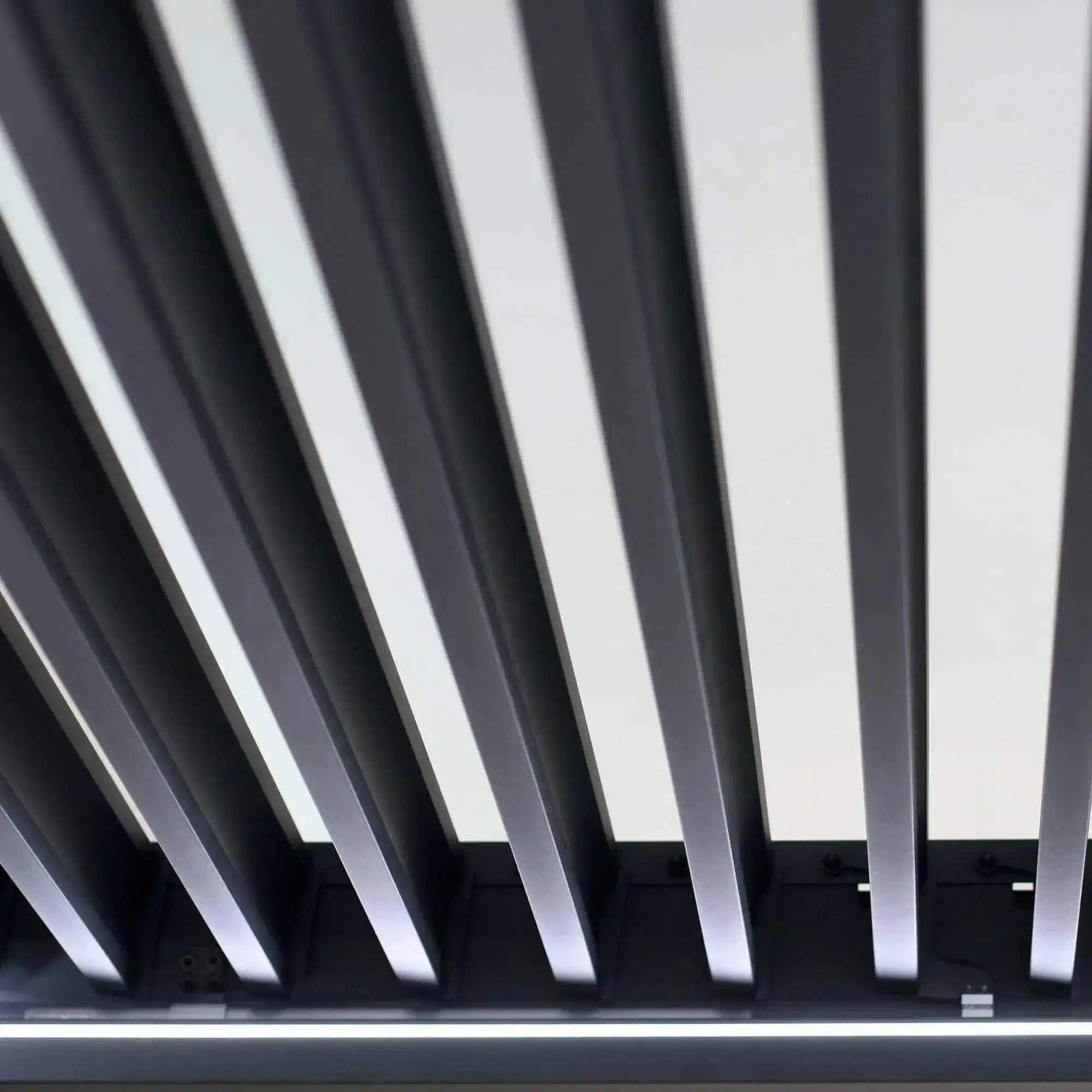 Die Pergola MotionFlex 300 von Wellis verfügt über einen Aluminiumrahmen in Mattanthrazit, elektrische Lamellen, eine integrierte LED-Beleuchtung und eine optionale Seitenbeschattung.