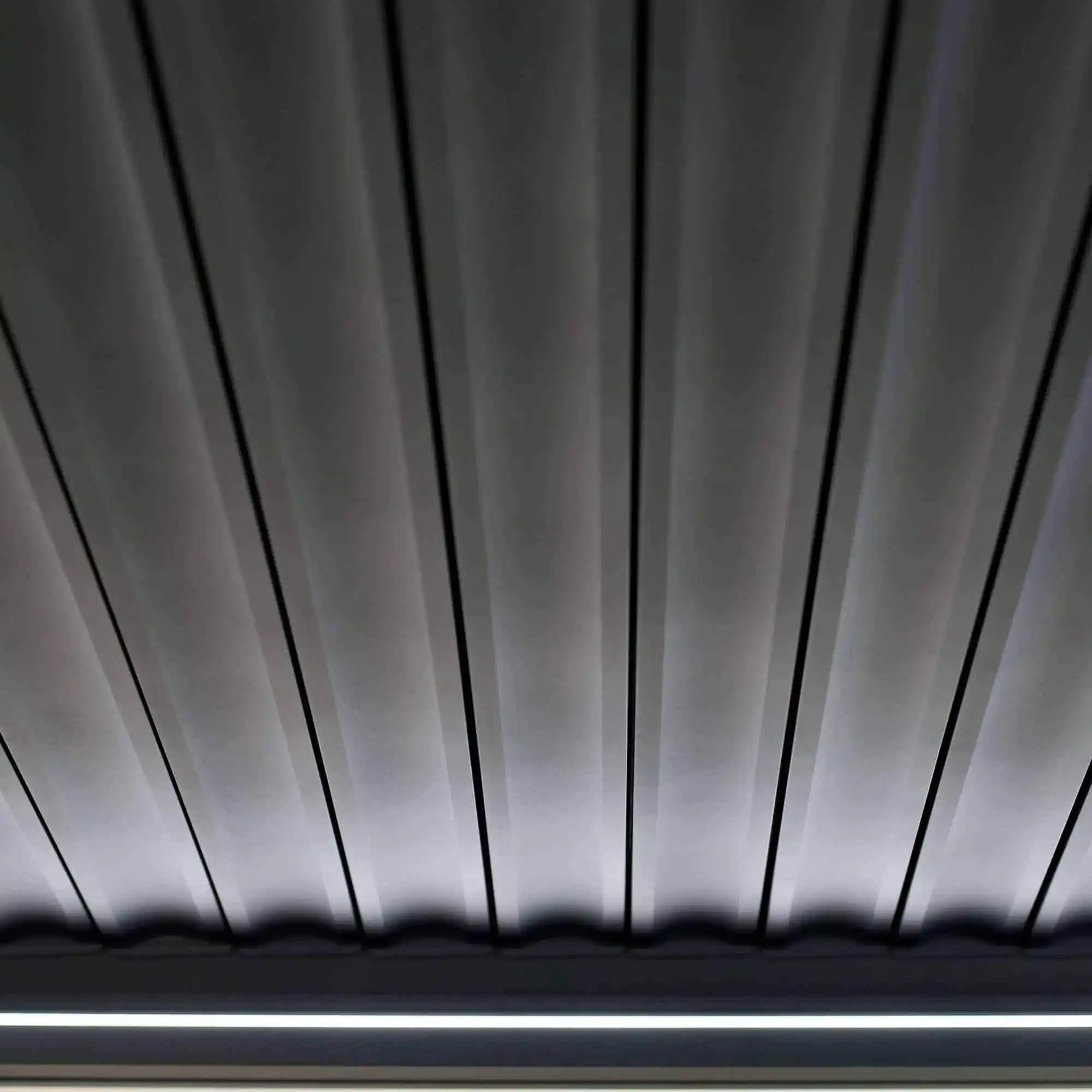 Die Pergola MotionFlex 300 von Wellis verfügt über einen Aluminiumrahmen in Mattanthrazit, elektrische Lamellen, eine integrierte LED-Beleuchtung und eine optionale Seitenbeschattung.